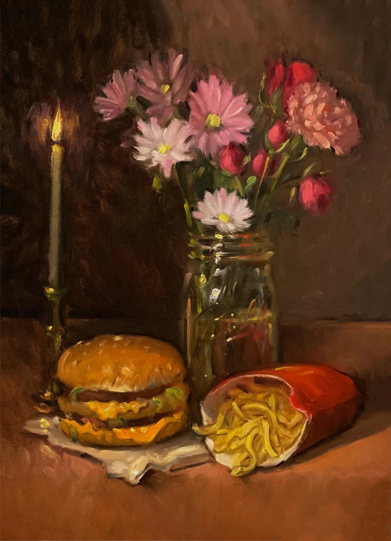 Still life with a hamburger, fries, and flowers in a jar on a table.