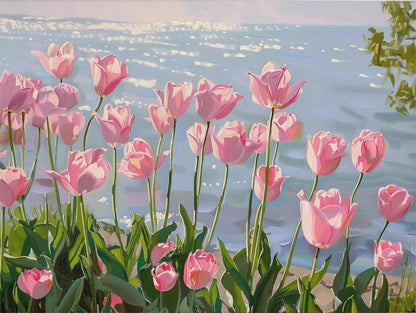 Pink tulips by a body of water with a soft focus background