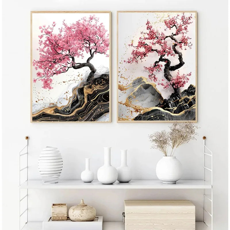 Two framed artworks of cherry blossom trees with abstract rock and gold accents on a white wall.