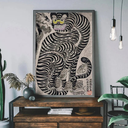 Framed artwork of a stylized tiger on a wooden console table with plants and books.