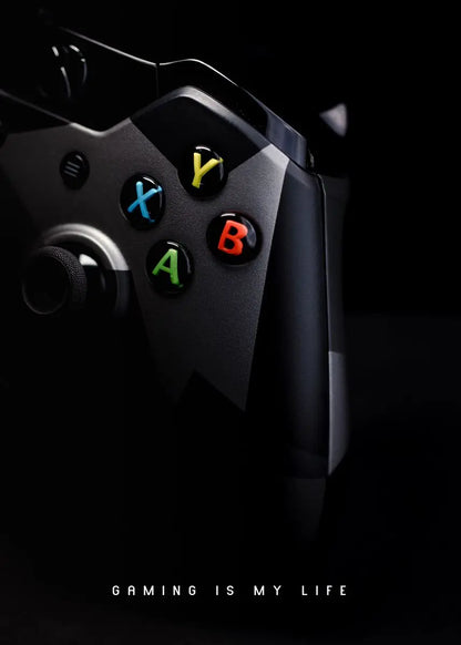 Close-up of a gaming controller with color-coded buttons on a black background, featuring the text 'Gaming is my life'.