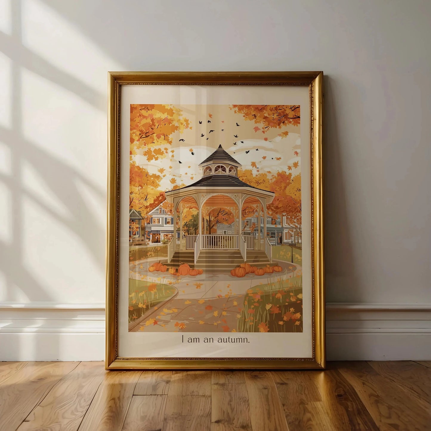 Framed autumn-themed artwork of a gazebo with pumpkins on a wall.
