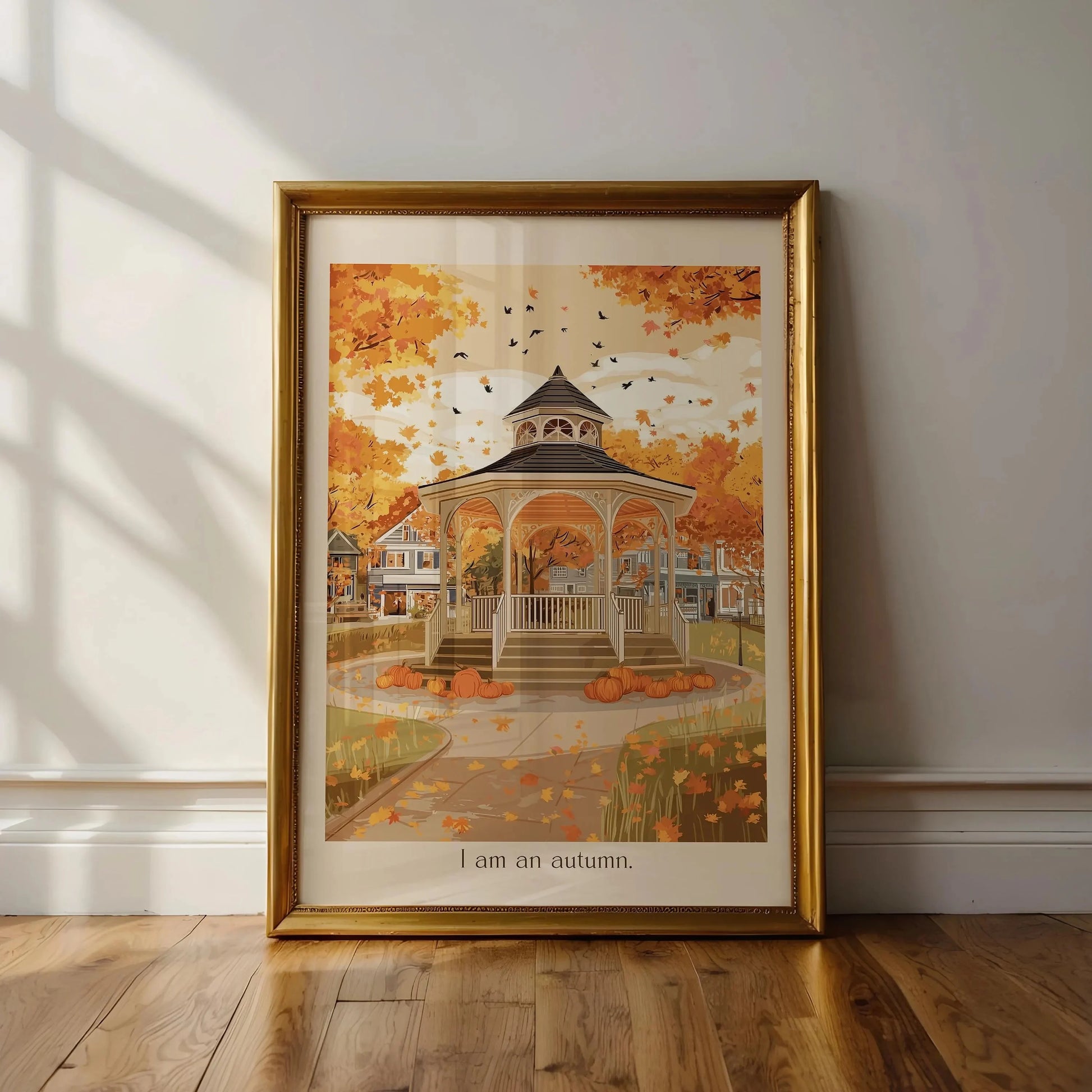 Framed autumn-themed artwork of a gazebo with pumpkins on a wall.