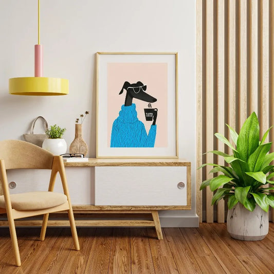 Modern interior with a framed artwork of a dog wearing sunglasses and a blue sweater, wooden chair, and potted plant. Canvas & Curio