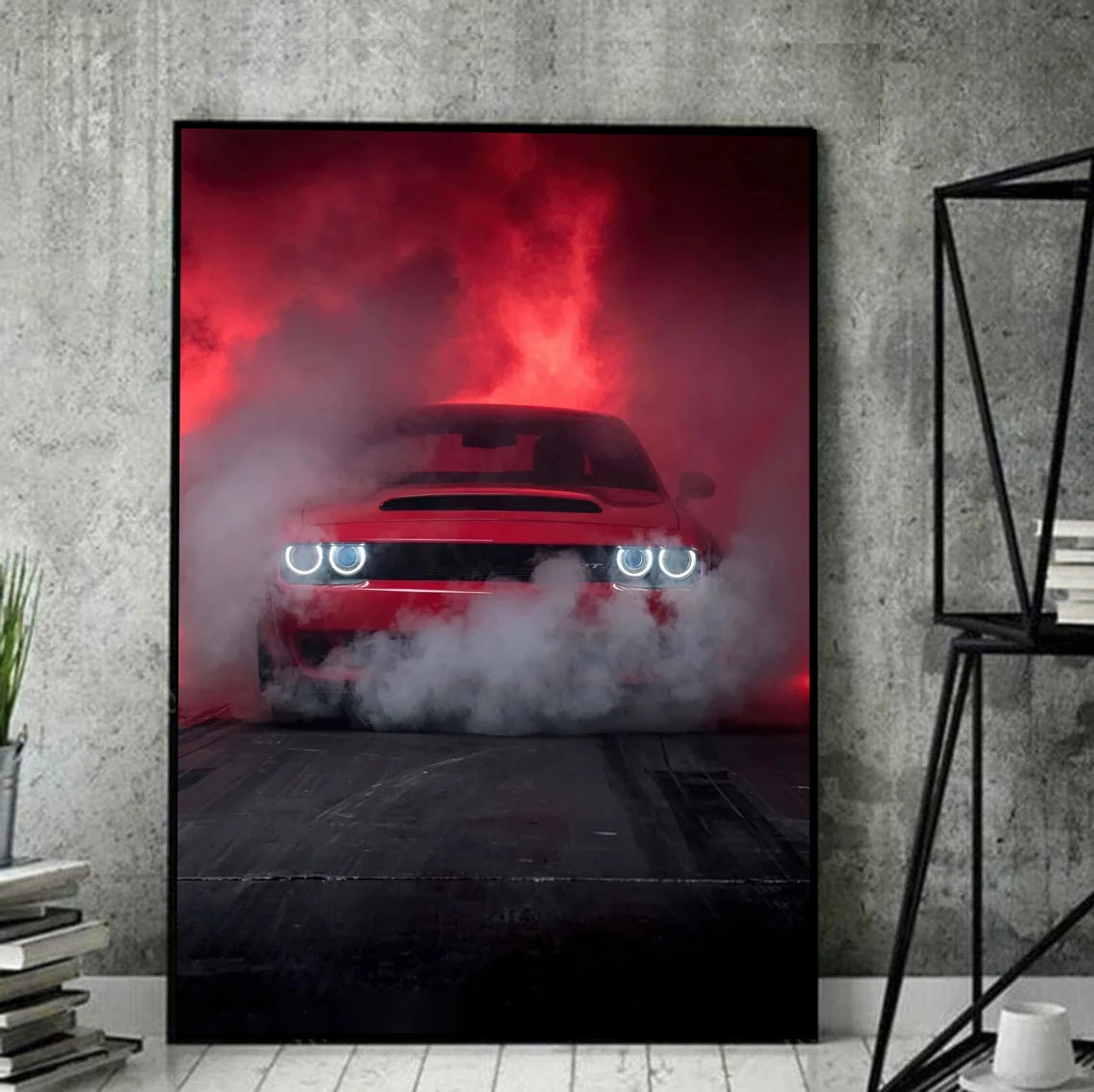 Framed poster of a red car with smoke effects on a concrete wall.
