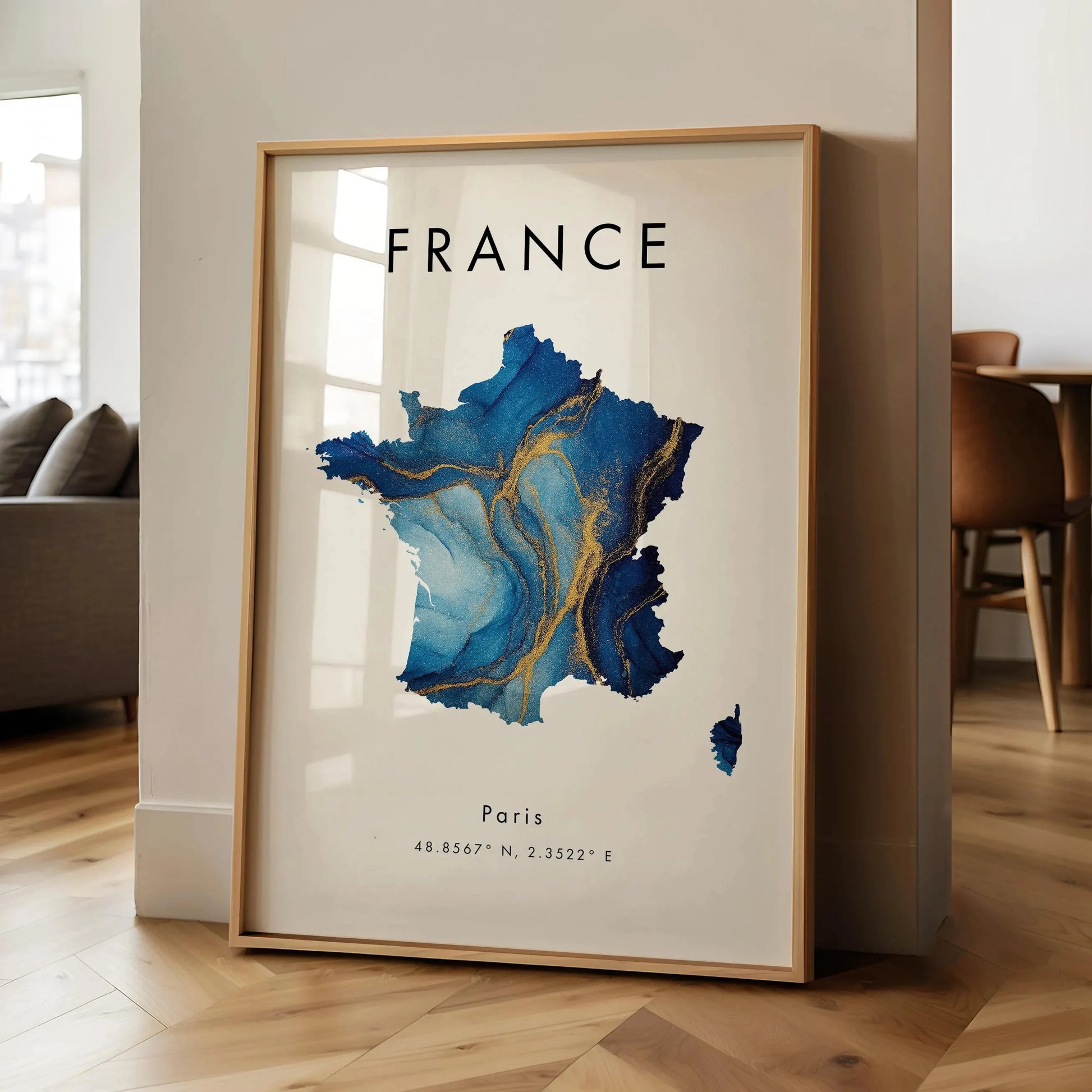 Framed map of France with Paris on a wall in a room.