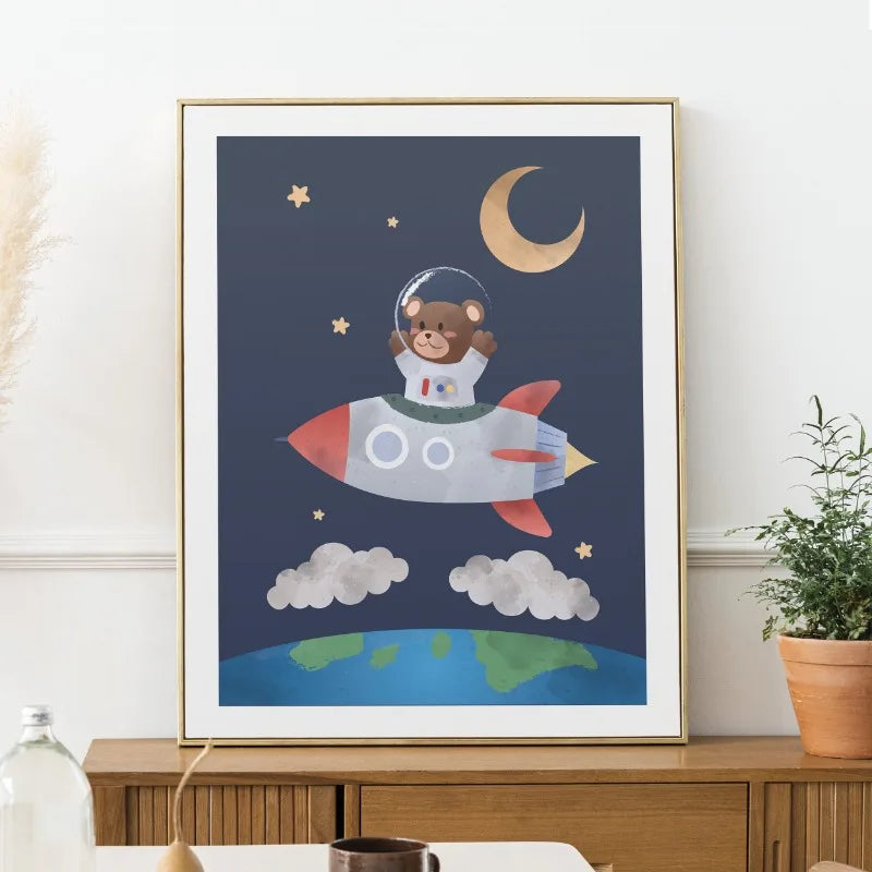 Framed children's poster of a bear astronaut on a rocket with Earth and moon in the background.