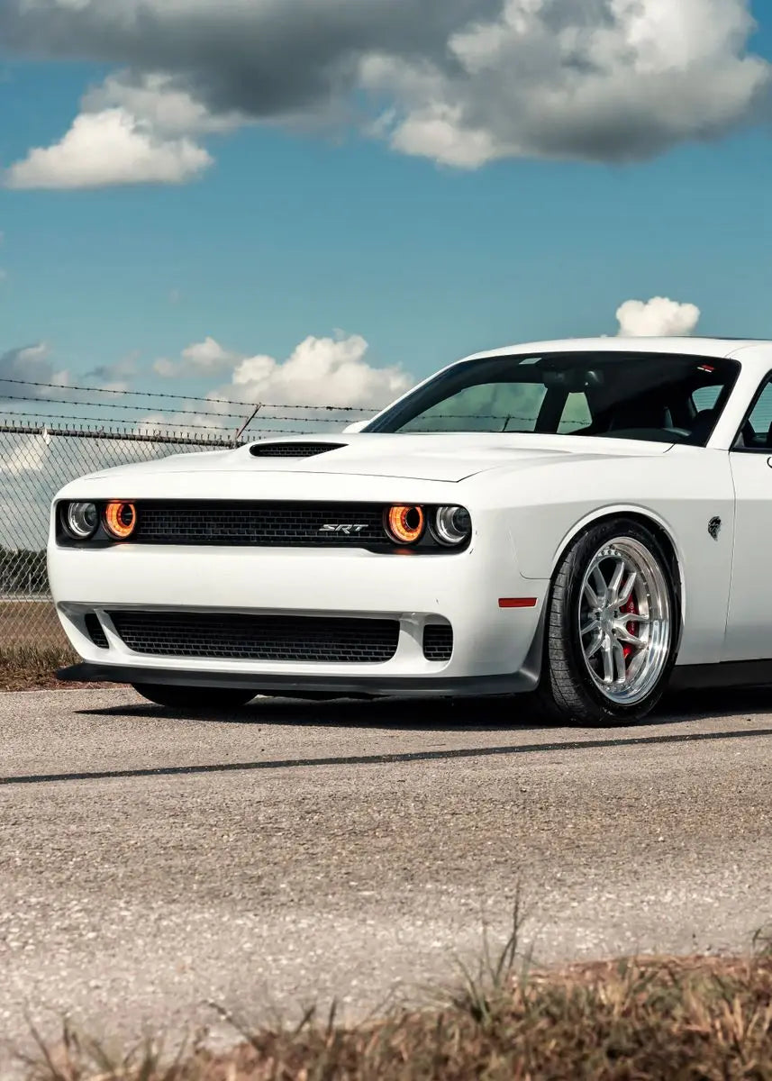 White muscle car on a road with a clear sky