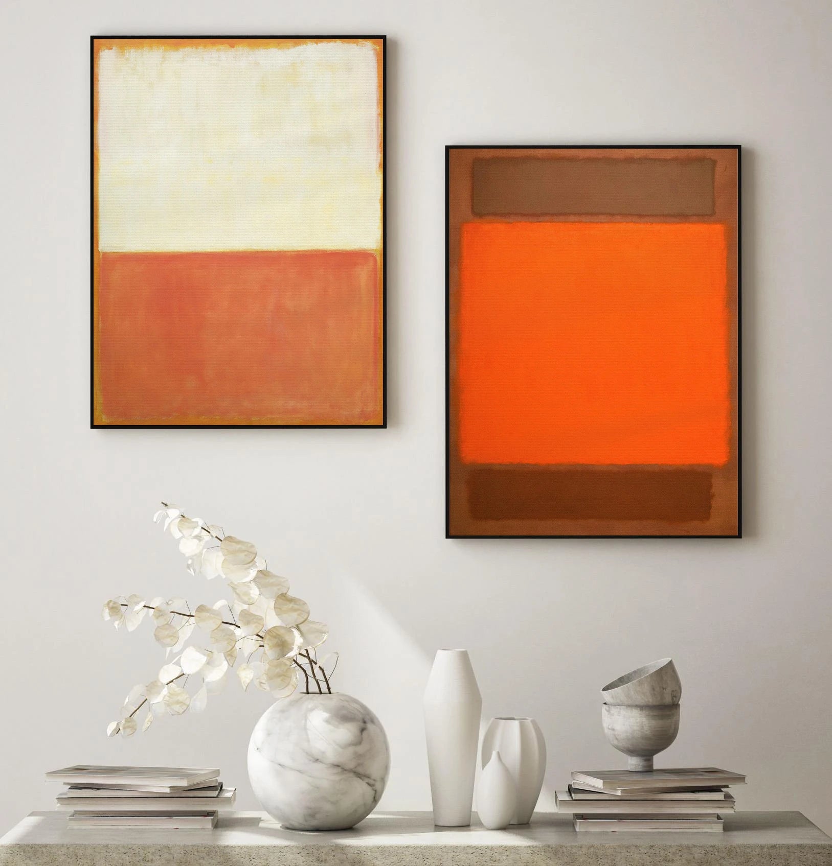 Two abstract paintings on a wall with decorative items on a table below.