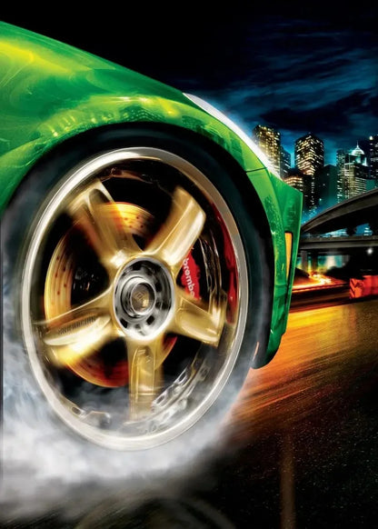 Close-up of a green car wheel with gold rim on a city street at night.