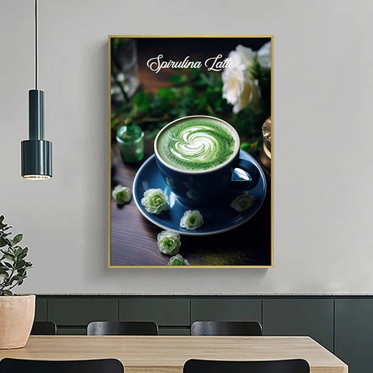 Framed artwork of a Spirulina Latte with a cup of green latte on a saucer, surrounded by greenery and flowers, hanging above a dining table. Canvas & Curio