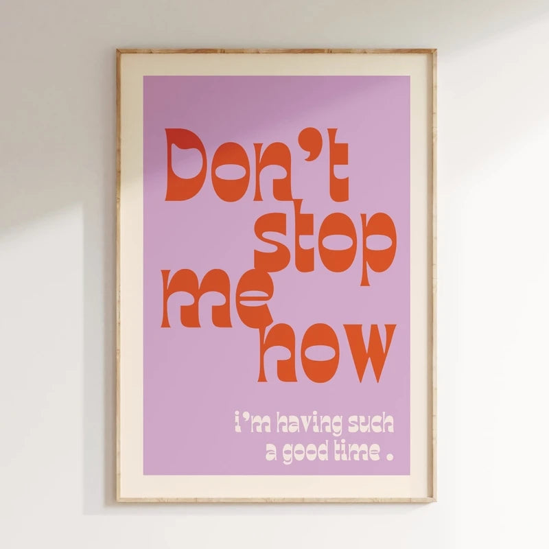 Framed poster with motivational quote 'Don't stop me now, I'm having such a good time' on a light purple background.