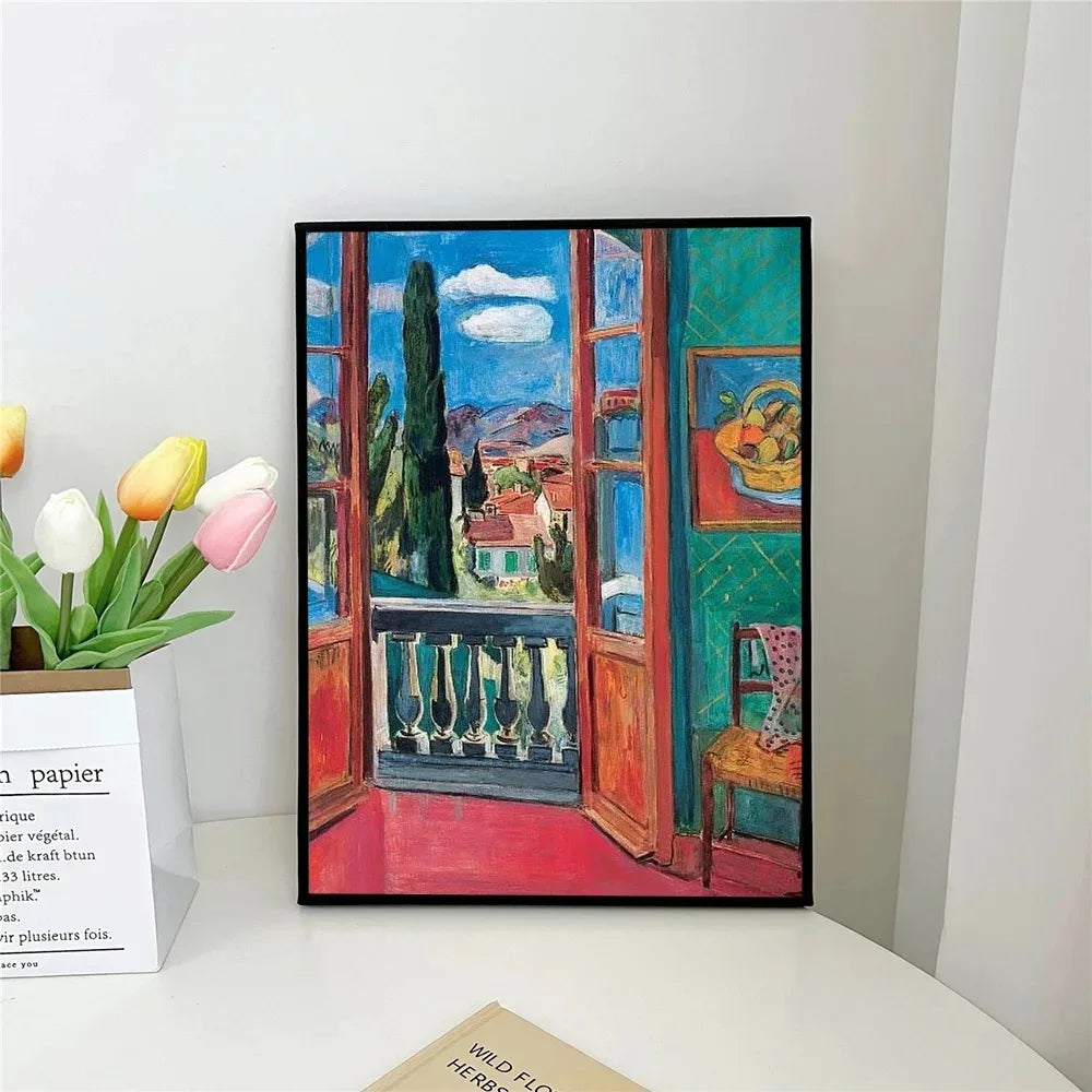 Framed painting of a colorful interior scene with an open window, placed on a white surface.