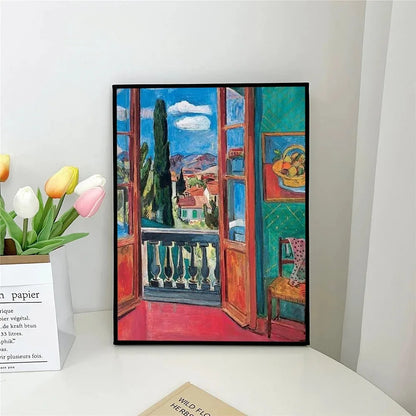 Framed painting of a colorful interior scene with an open window, placed on a white surface.