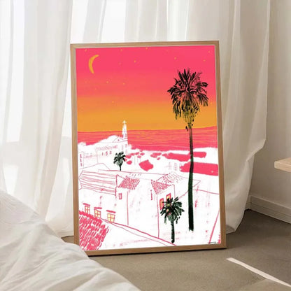 Framed artwork of a sunset over a coastal town with palm trees, displayed indoors.