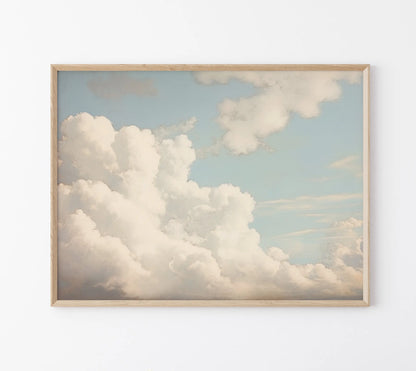 Framed artwork of a cloud scene on a white wall