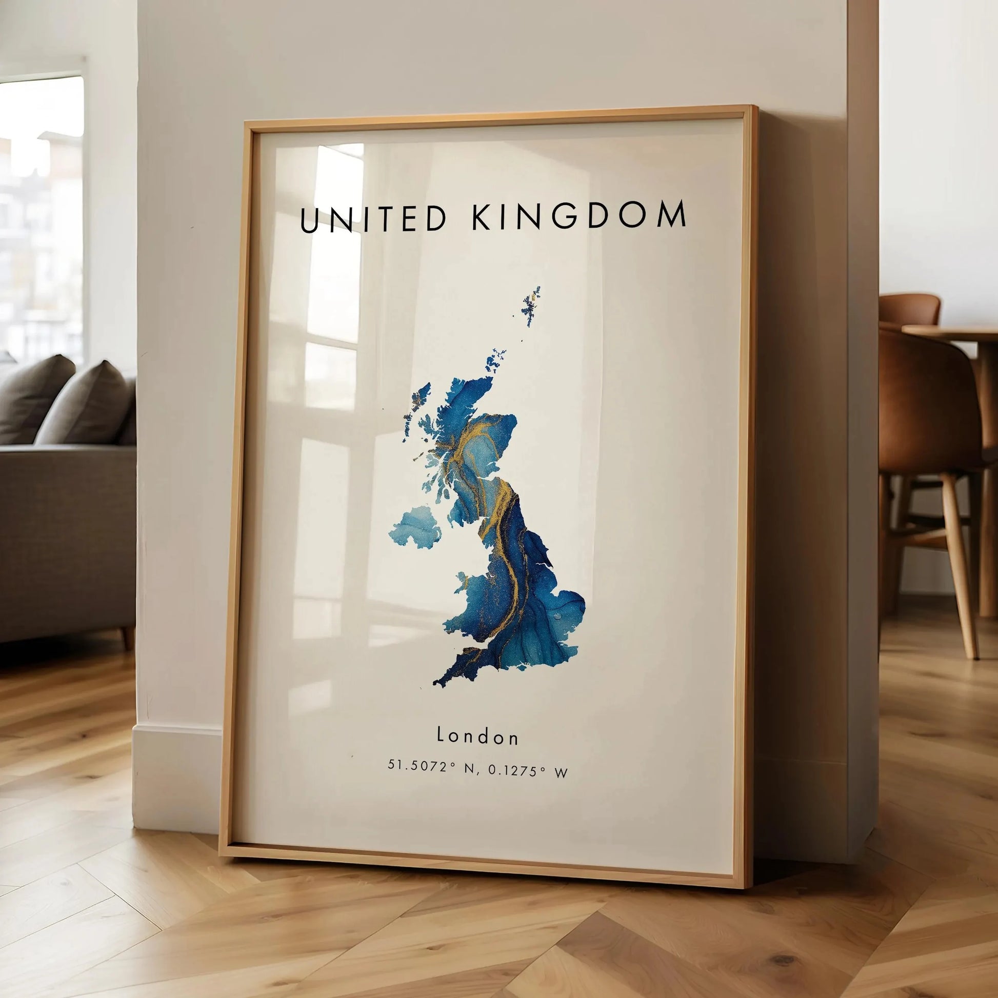Framed map of the United Kingdom on a wall in a room with wooden flooring.