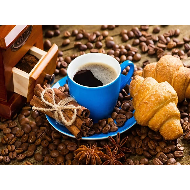 Blue cup of coffee with croissants and coffee beans on a wooden surface
