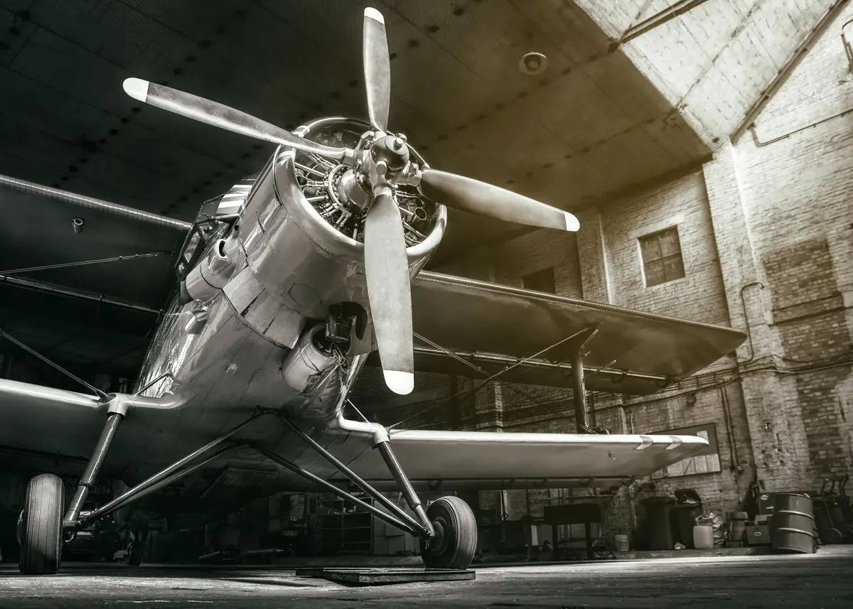 Vintage airplane with a propeller inside a hangar.