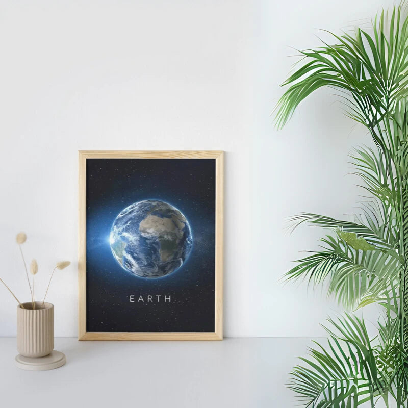 Framed print of Earth on a white wall with a plant and vase in the foreground