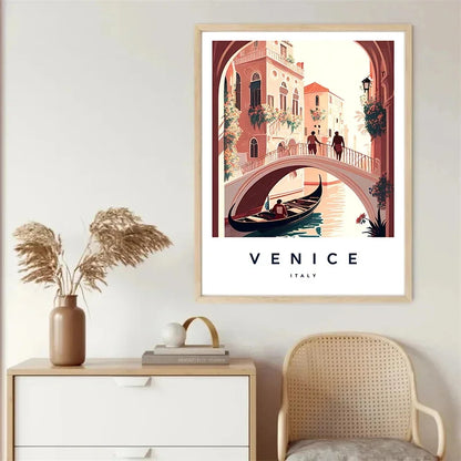 Framed artwork of Venice with a gondola and bridge, displayed on a wall above a side table and chair.